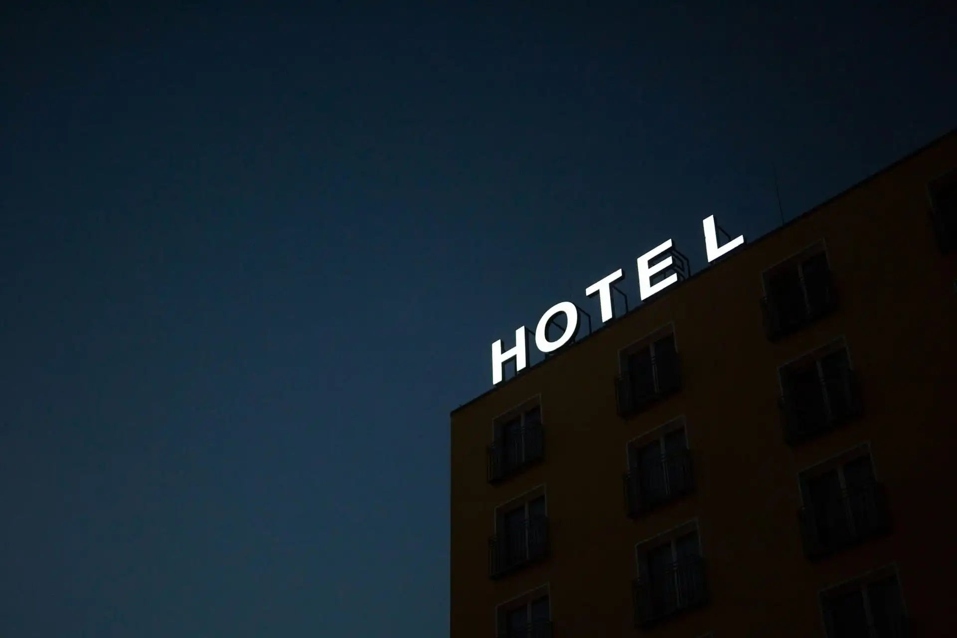 An illuminated hotel sign on a building facade at night